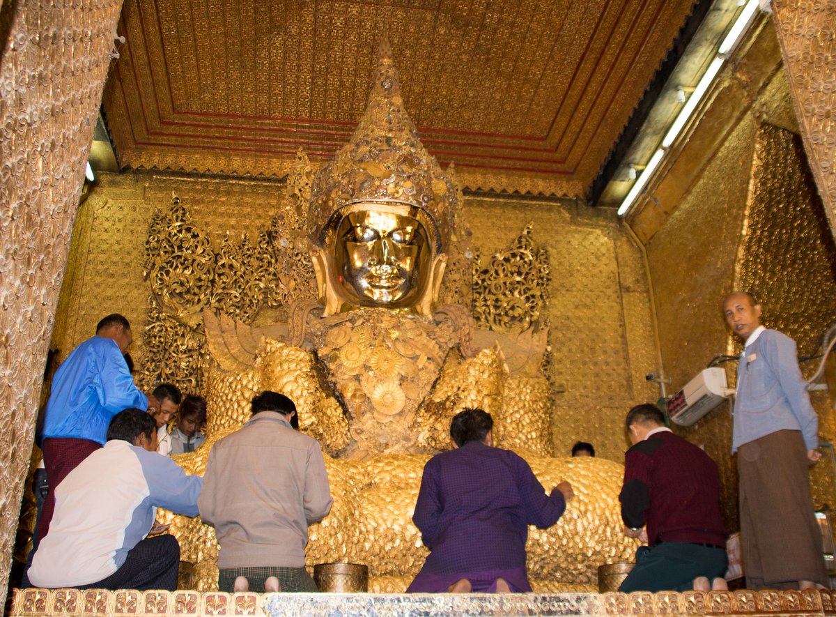 Putting gold leaf on a Buddha Putting gold leaf on a Buddha